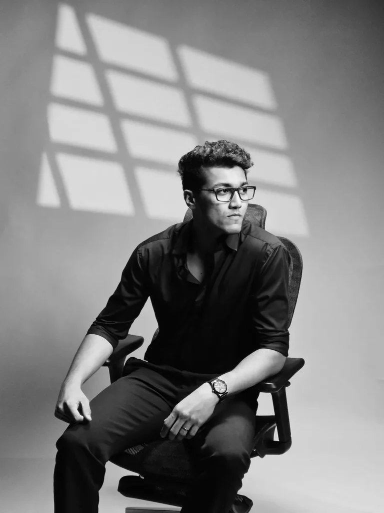 Black and white portrait of Nihaal, a digital marketing expert in Dubai, sitting in an office chair looking thoughtful